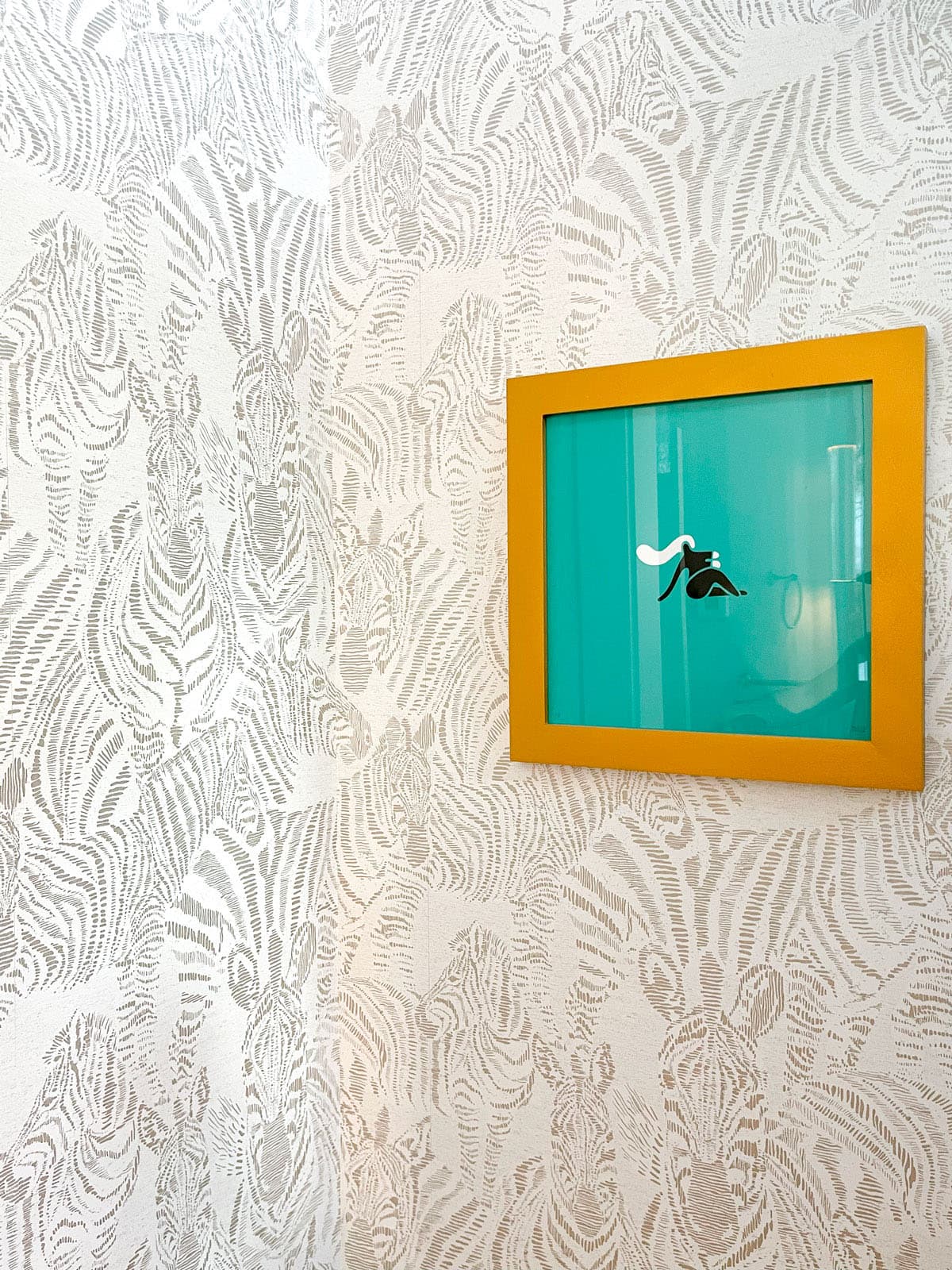 Vignette of bathroom wallpaper and custom artwork in a rustic remodel interior design project in Jackson Wyoming